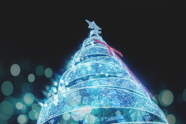 Foto vista ad angolo basso dell'albero di natale illuminato contro il cielo di notte