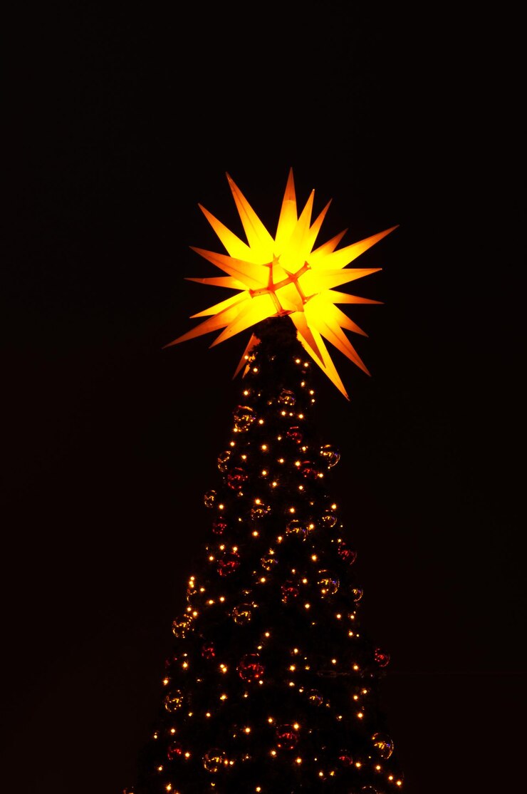 फोटो low angle view of illuminated christmas tree against sky at night