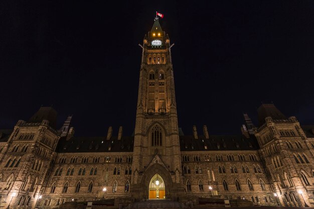 Low angle view of illuminated clock tower at night