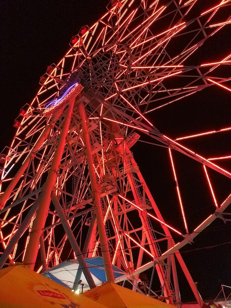 Low angle view of illuminated ferris wheel against sky at night