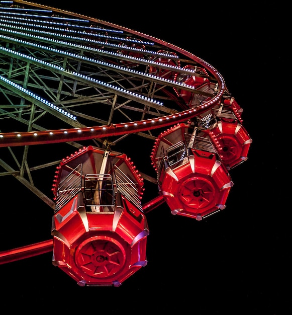 Low angle view of illuminated ferris wheel against sky at night