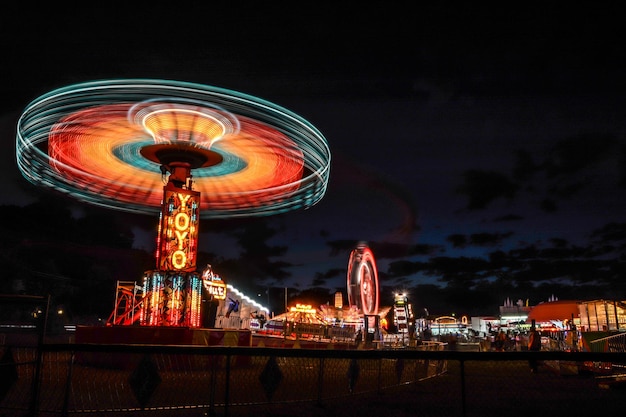 夜の遊園地で照らされたフェリスホイールの低角度の眺め