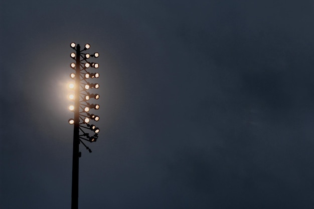 Photo low angle view of illuminated flood light against sky at night