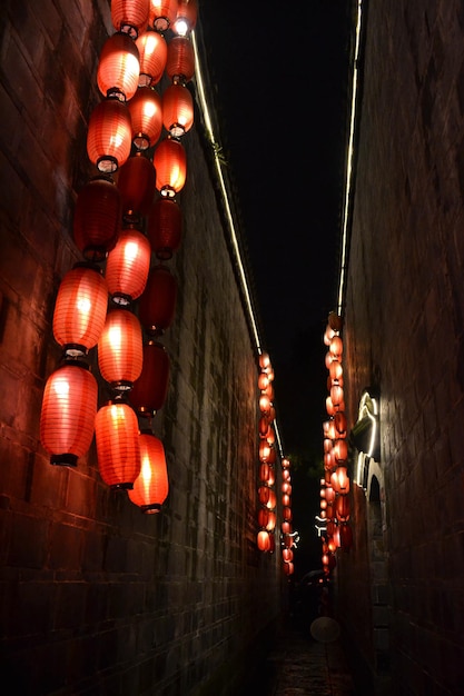 low angle view of illuminated lanterns hanging against wall