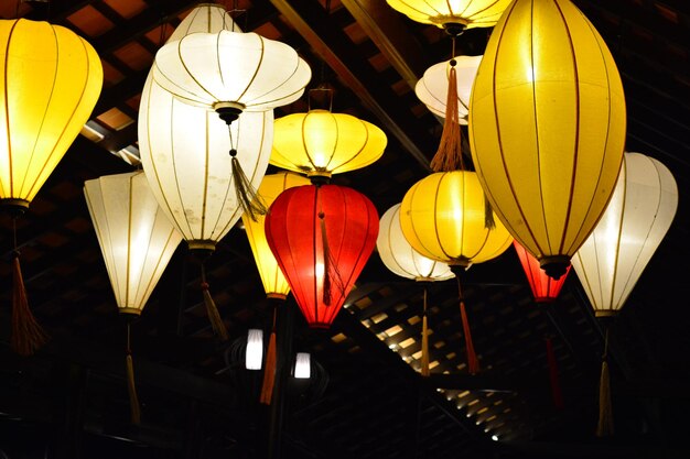 Photo low angle view of illuminated lanterns hanging on ceiling