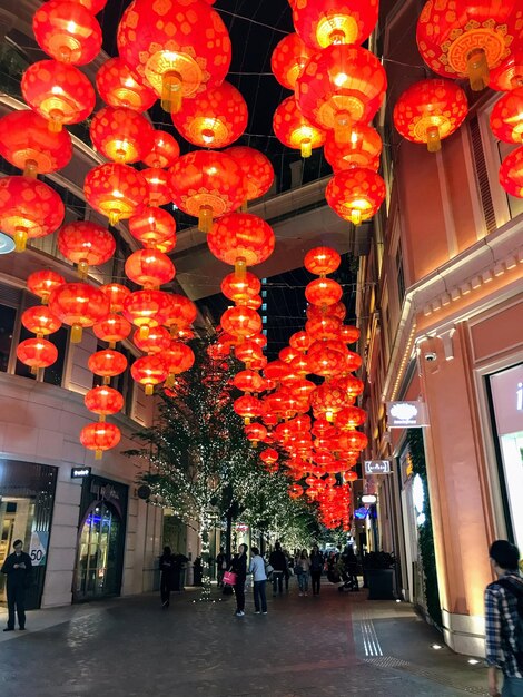 Low angle view of illuminated lanterns hanging in city at night