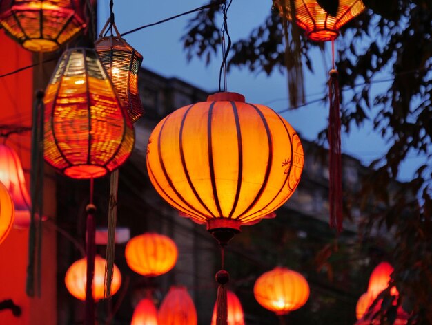 Low angle view of illuminated lanterns hanging at dusk