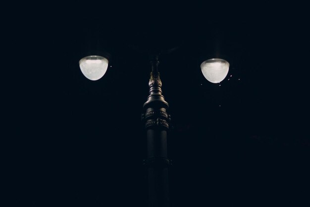 Foto vista a basso angolo di una lampadina illuminata contro il cielo di notte