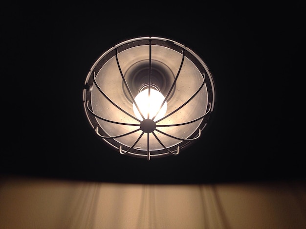 Photo low angle view of illuminated light bulb in darkroom