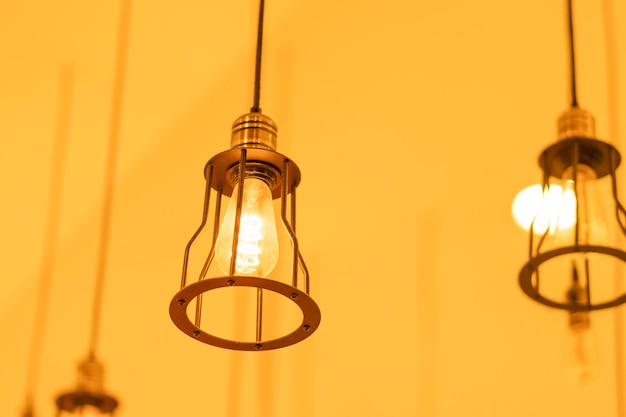 Low angle view of illuminated light bulb hanging on ceiling