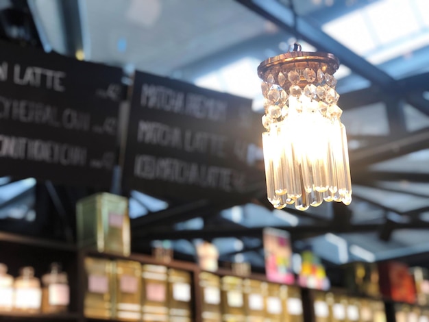 Low angle view of illuminated light bulb hanging on ceiling