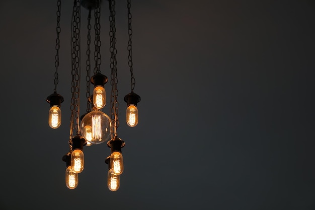Low angle view of illuminated light bulbs against wall