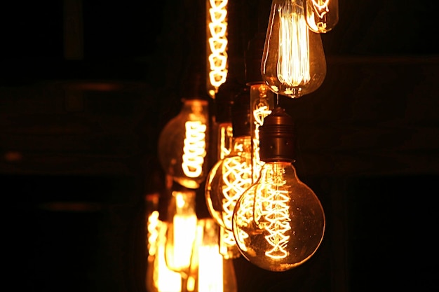 夜に吊るされた照明電球の低角度のビュー