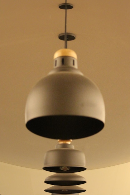 Low angle view of illuminated lighting equipment on ceiling at home