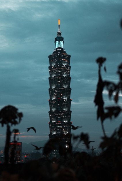 Low angle view of illuminated office building against cloudy sky at dusk