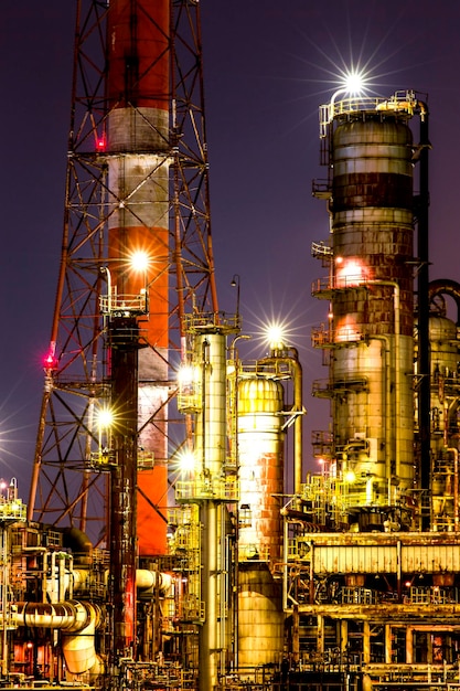 Photo low angle view of illuminated oil industry against sky at night