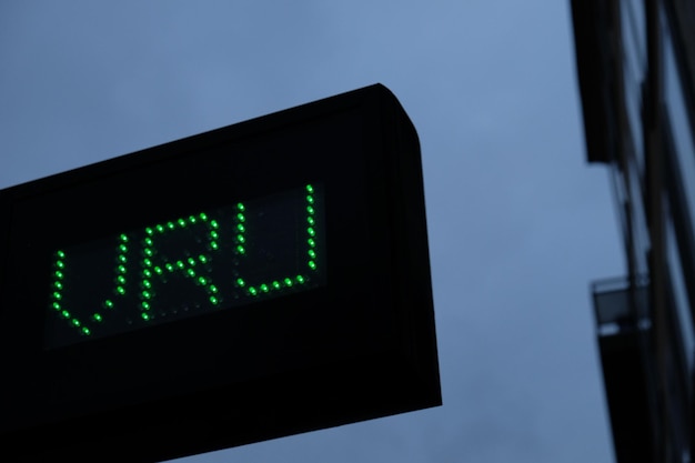 Photo low angle view of illuminated sign board against sky at dusk