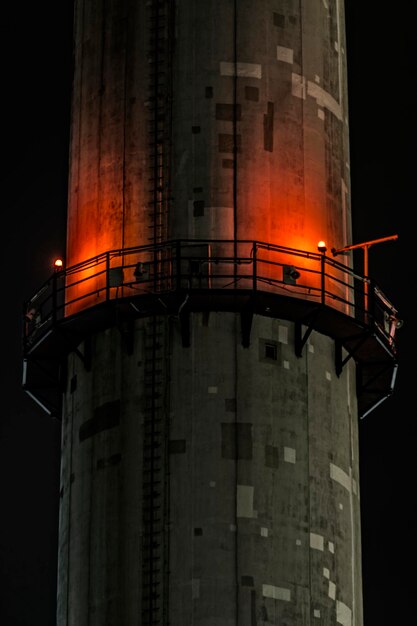 Photo low angle view of illuminated smoke stack against clear sky at night