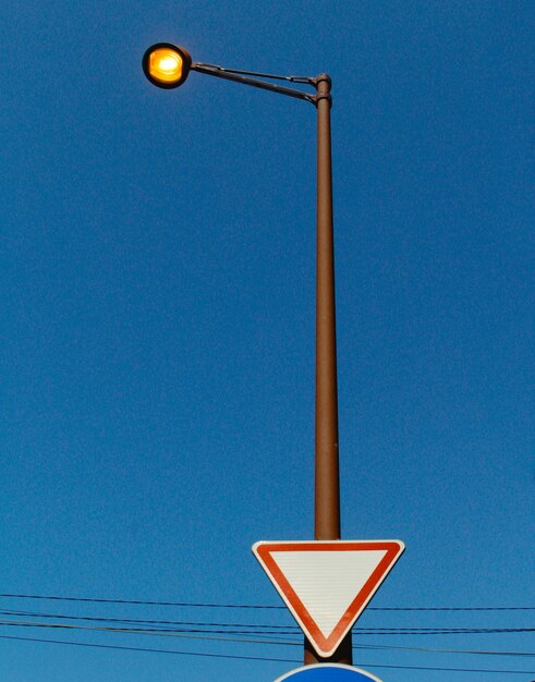 Low angle view of illuminated street light against blue sky