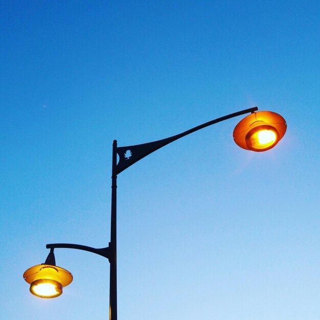 Low angle view of illuminated street light against sky