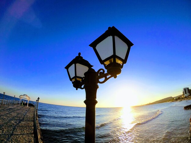 Low angle view of illuminated street light against sky