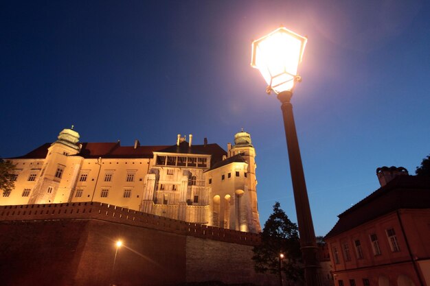 Low angle view of illuminated street light by the king castle against clear sky at dusk