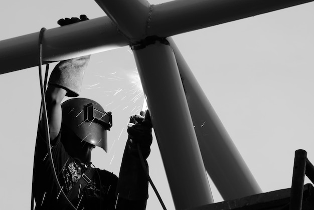 Photo low angle view of industry worker with welding steel repairing metal