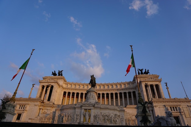 Foto vista a basso angolo delle bandiere italiane di fronte all'edificio storico contro il cielo