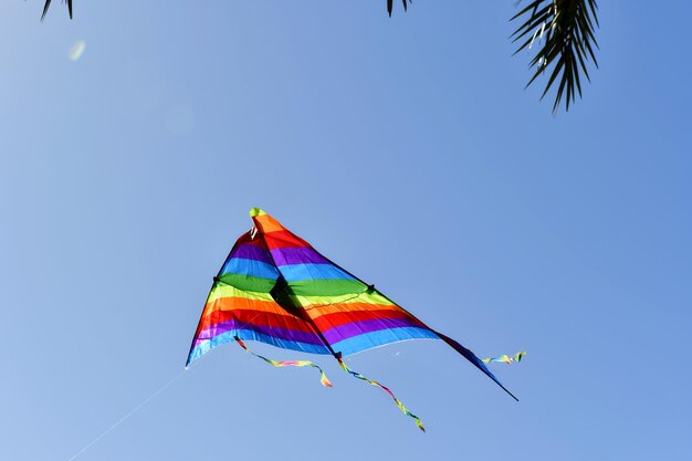 Low angle view of kite against clear blue sky