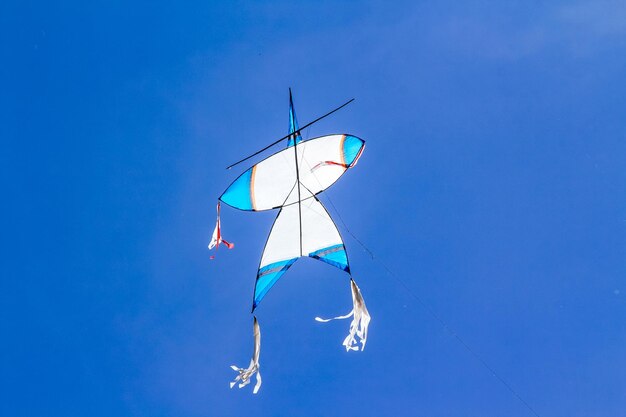 Low angle view of kite flying against clear blue sky