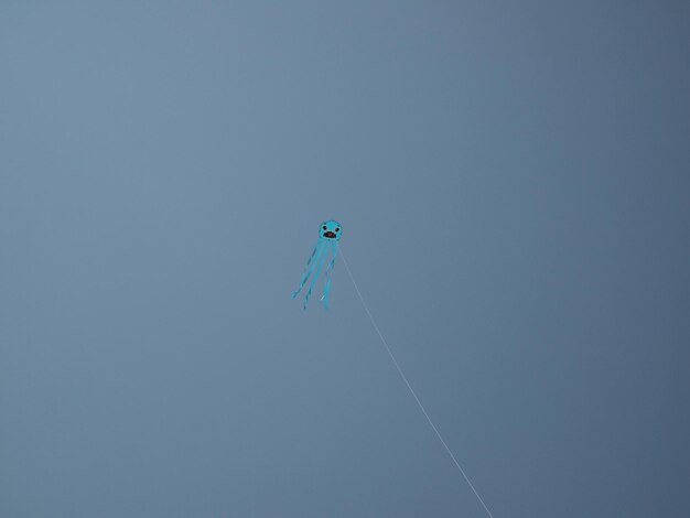 Photo low angle view of kite flying against clear sky