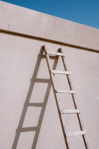 low angle view of ladder on building wall during sunny day