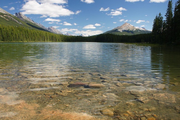 Low angle view of lake against mountains and blue sky