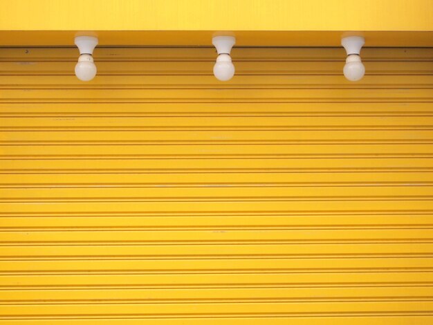 Low angle view of lamp against orange wall