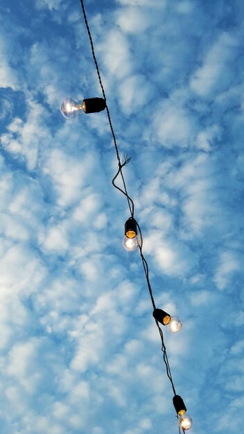Low angle view of lamp hanging against sky