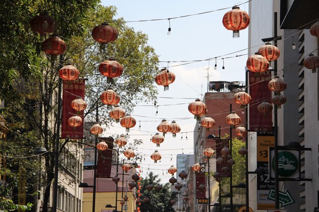 Photo low angle view of lanterns hanging amidst buildings in city