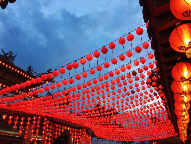 Low angle view of lanterns hanging by building against sky