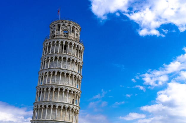 Low angle view of the Leaning Tower of Pisa under the sunlight and a blue sky at daytime in Italy