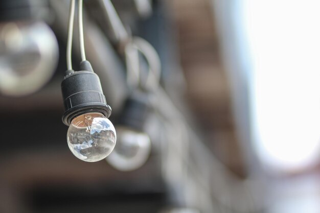 Photo low angle view of light bulb hanging from ceiling