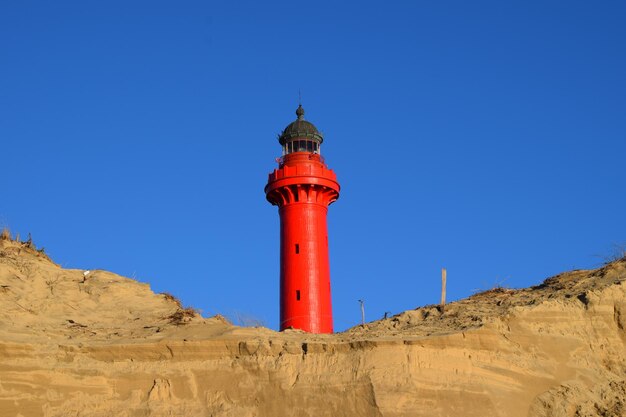 Foto vista a basso angolo del faro contro un cielo blu limpido