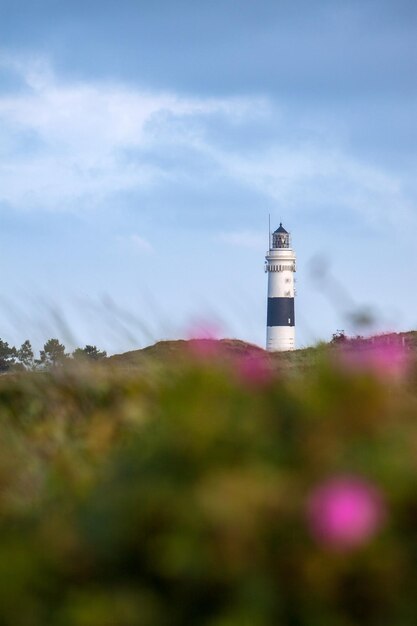 Low angle view of lighthouse by building against sky