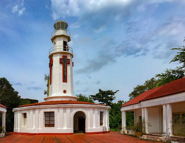 Foto vista a basso angolo del faro dall'edificio contro il cielo