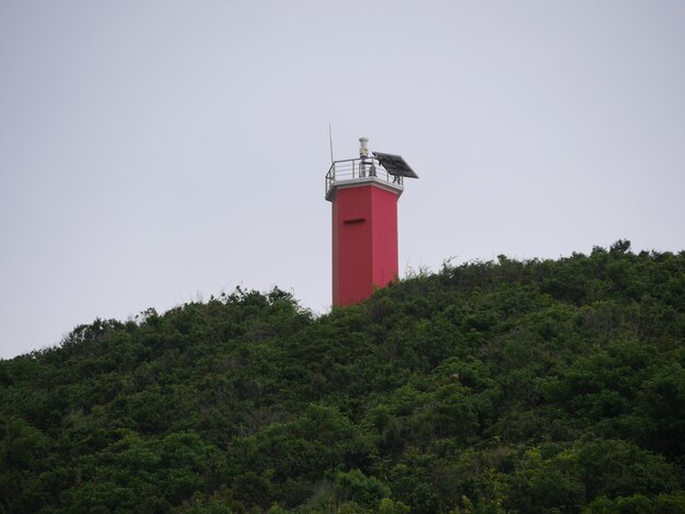 Low angle view of lighthouse by building against sky