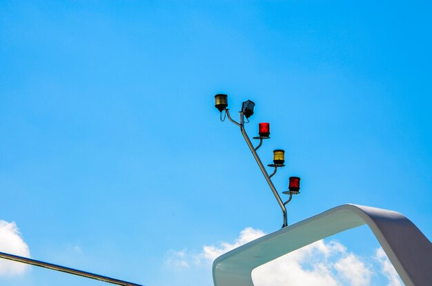 Low angle view of lighting equipment against blue sky