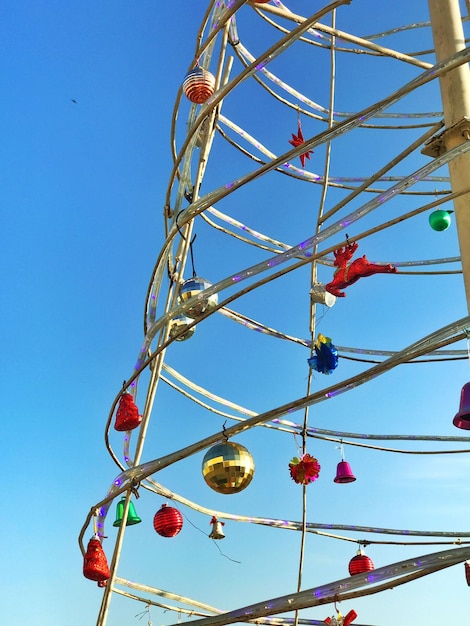 Low angle view of lighting equipment hanging against clear blue sky