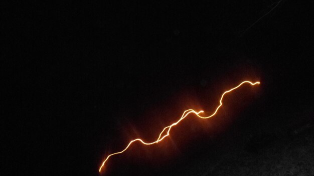 Low angle view of lightning against sky at night