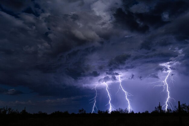 Photo low angle view of lightning over silhouette landscape at night