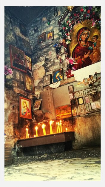 low angle view of lit candles by virgin mary frame in church