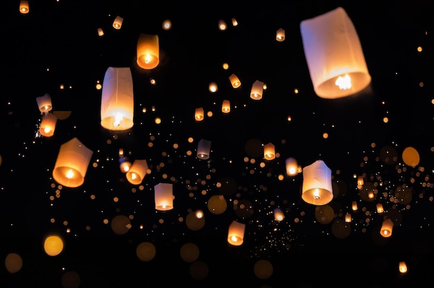 Low angle view of lit lanterns flying at night
