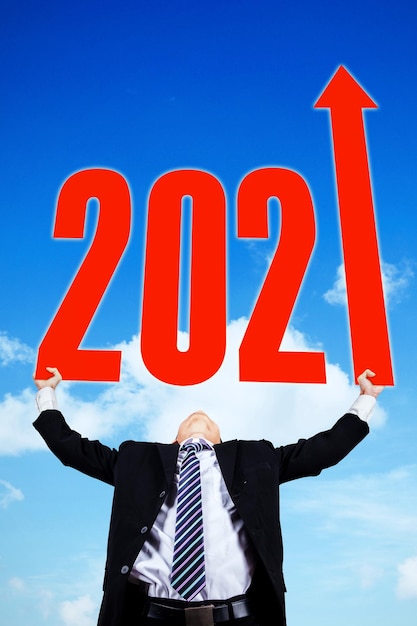 Low angle view of male manager holding number 2021